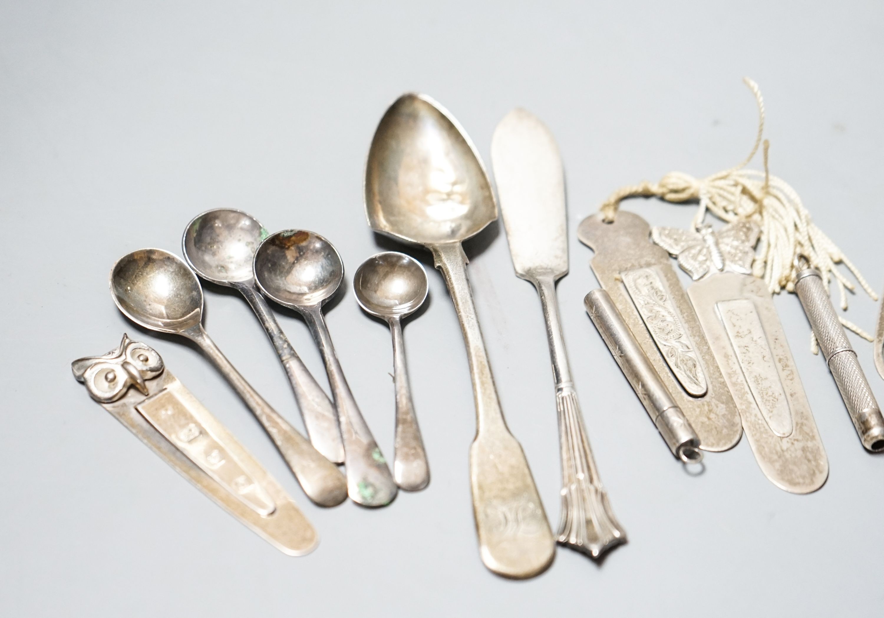 Five assorted silver bookmarks, a white metal cased toothpick, spoons etc.